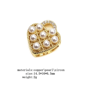 Detail of a hollow heart pendant in gold finish with pearls and zircon inlay