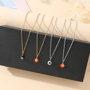 Detail of four colorful evil eye charm necklaces on decorative display blocks