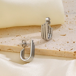 Three-layer irregular silver U-shaped line stud earrings on elegant silk and stone background