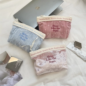 Dettaglio delle borse cosmetiche in velluto con ricamo Shine Like the Stars sulla tasca