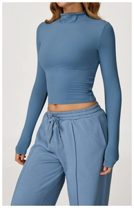 Detail of blue long-sleeve yoga top with thumbholes and matching drawstring joggers