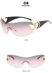 Detail of rimless Y2K sunglasses with gradient pink lenses and gold heart metal accents