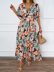 Detail eines sommerlichen Maxikleids mit Blumenmuster, V-Ausschnitt und Seitenschlitz