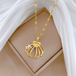 Detailed close-up of golden shell pendant with starfish detail and water wave chain necklace