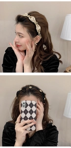 Detail of beige and black camellia headbands with gold flower accents on a model