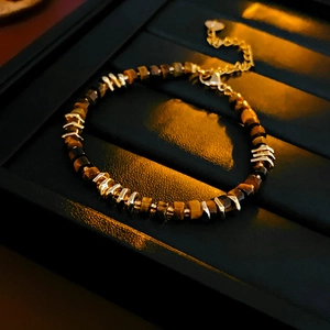 Detail of tiger eye stone beads and gold metal spacers with adjustable lobster clasp