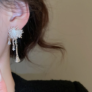 Close-up of zircon snowflake tassel earrings with silver finish and hanging gems