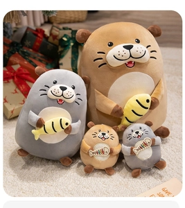 Group shot of grey and brown sea otter plush toys with small yellow fish accessories