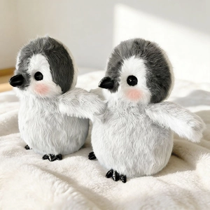 Zwei runde Pinguin-Plüschtiere mit flauschigem grau-weißem Fell und rosa Wangen
