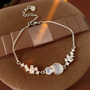 Macro detail of silver bow bracelet with purple gemstones on elegant jewelry box