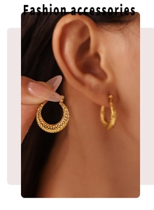 Macro detail of gold C-shape hoop earrings with hammered texture on model