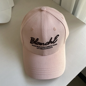 Détail de la casquette rose clair avec broderie Blanche noire et coutures de précision