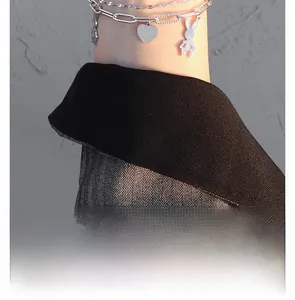 Close-up of double-layered silver chain necklace with rabbit and heart pendants on neck