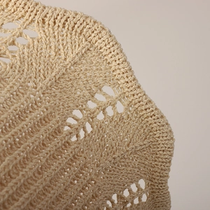 Close-up of beige crochet lace pattern showing breathable hollow knit texture on sun hat