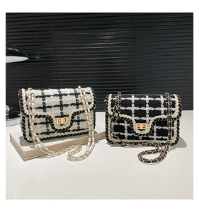 Detail van tweed crossbodytassen met gevlochten rand, metalen sluiting en kettingriemen