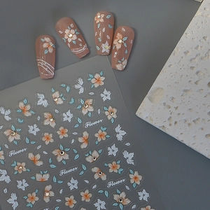 3D floral embossed nail art stickers with orange flowers and crystals on pink manicure