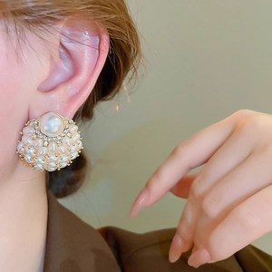 Detail of French vintage pearl flower earrings with gold plating worn by model