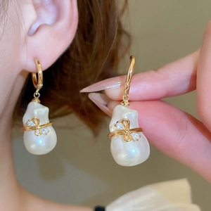 Détail de la boucle d'oreille nœud papillon plaquée or 18 carats avec perle baroque
