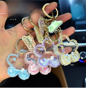 Detail of transparent acrylic sakura keychain with colorful liquid sand and glitter