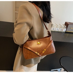 Dettaglio della borsa retrò marrone con chiusura girevole dorata e finiture in pelle a V
