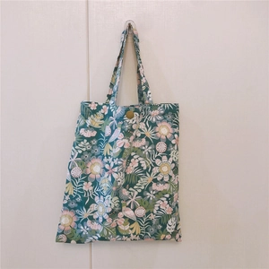 Vue détaillée du sac floral vert foncé avec un bouton-pression en métal doré