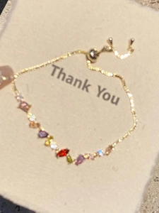 Detail of 18k gold plated adjustable bracelet with colorful teardrop zircon crystals