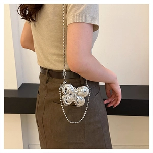 Chic silver butterfly metal box bag with long bead chain strap shown on a model