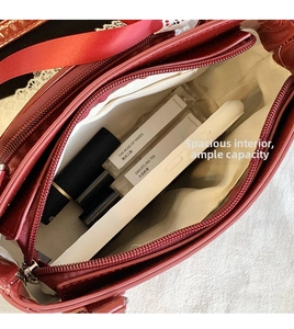 Top view of red glossy crossbody bag showing interior lining and zipped pocket storage