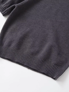 Détail de l'ourlet et des poignets côtelés du pull en tricot gris foncé chiné