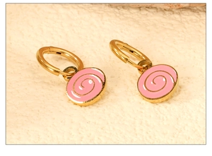 Macro shot of 18K gold plated stainless steel hoop earrings with pink spiral fruit pendants