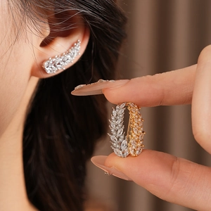 Detailed view of wheat ear pearl earrings with zircon stones in gold and silver finish