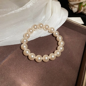 Détail d'un bracelet en perles dorées 18 carats avec perles rondes sur velours