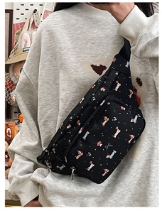 Detail of cute dachshund cartoon print on black fabric chest bag with zipper