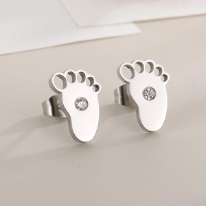 Detailed view of silver steel footprint stud earrings with a sparkling zircon inlay