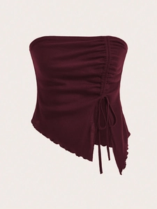 Detailed close-up of dark red ribbed fabric with side drawstring and irregular hemline