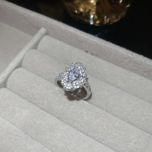 Close-up of silver flower ring with marquise zircon and double halo on velvet