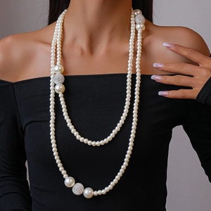 Double-layered pearl necklace with rhinestone-encrusted spheres on an elegant model