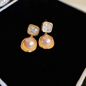 Vintage gold geometric earrings featuring cubic zirconia and imitation pearls on black box
