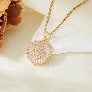 Close-up of a heart pendant necklace featuring pink gems and micro-set zircons on a gold chain