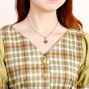 Elegant rose gold tree of life pendant necklace displayed on a model's neck