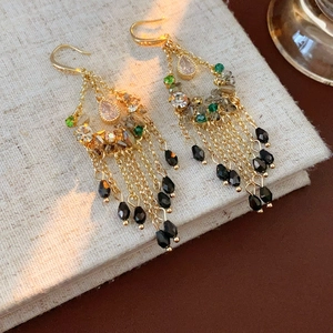 Detail of vintage gold tassel earrings with colorful beads and pear-shaped crystal drops