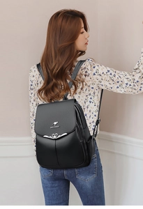 Close-up of black leather backpack featuring heart buckle and metal BAGLOU DAISHU logo