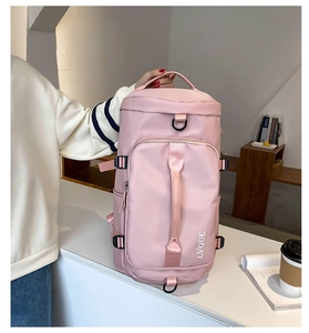 Pink cylindrical travel bag showing adjustable straps and multiple zip compartments