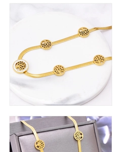 Detail of gold tree of life pendant with sparkling crystals on smooth snake chain