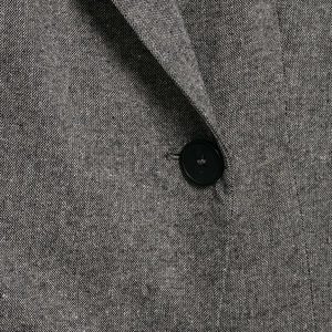 Women's professional grey textured blazer with a black button detail and fabric texture
