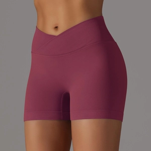 Dettaglio dei pantaloncini da yoga rosso rosa a vita alta con fascia incrociata a coste
