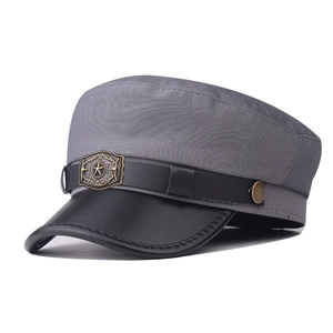 Detailed shot of grey fabric military hat with black leather brim and star metal badge