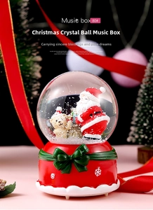 Close-up of a Christmas music box with Santa Claus and a bear inside a glass snow globe