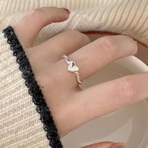 Minimalist 925 silver heart ring with twisted band design worn by a female model