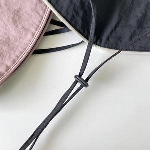Detail of adjustable chin strap and plastic buckle on nylon foldable sun hats